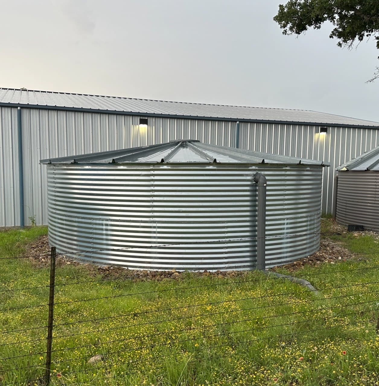 25,000 gallon metal rainwater collection tank used to completely supply water for household or agricultural/industrial applications.