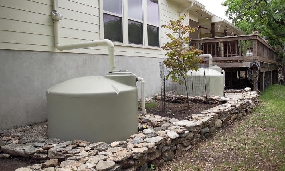 Two large rainwater collection tanks used to collect for household needs.