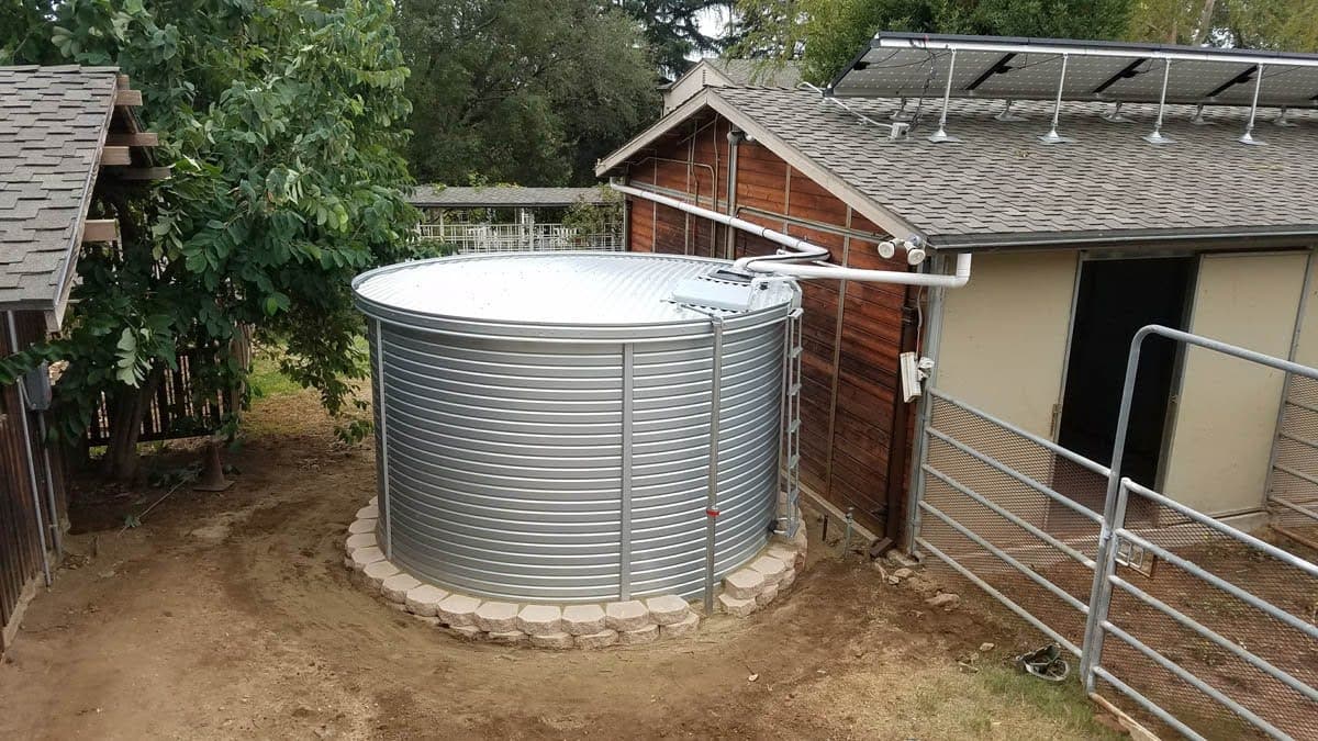 A single large metal rainwater collection tank to fully supply water needs for a household.
